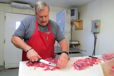Photo by Marty Cheek Dan Keith carefully slices a piece of flap steak in the Rocca’s Market meat department. Keith specializes in making a variety of sausages.